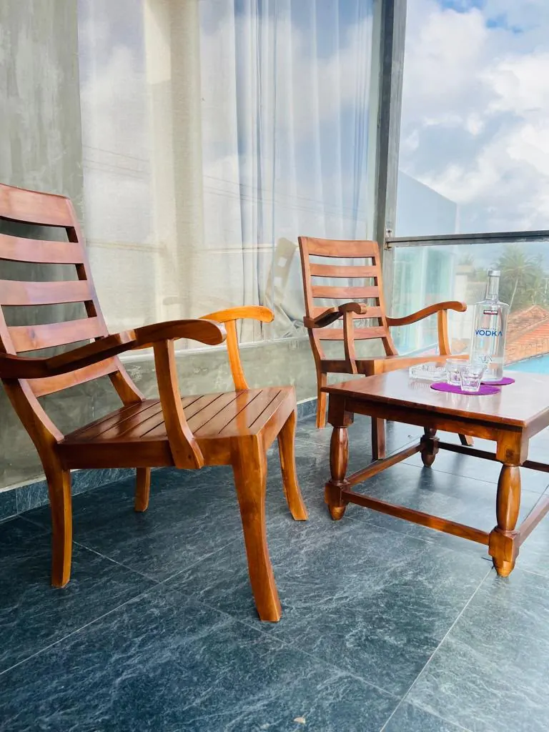 Two wooden armchairs beside a large sea facing window