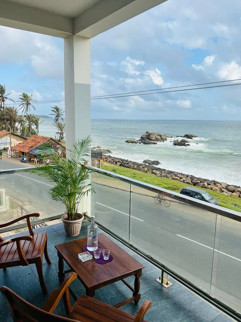 Private balcony seating overlooking the ocean and coast road