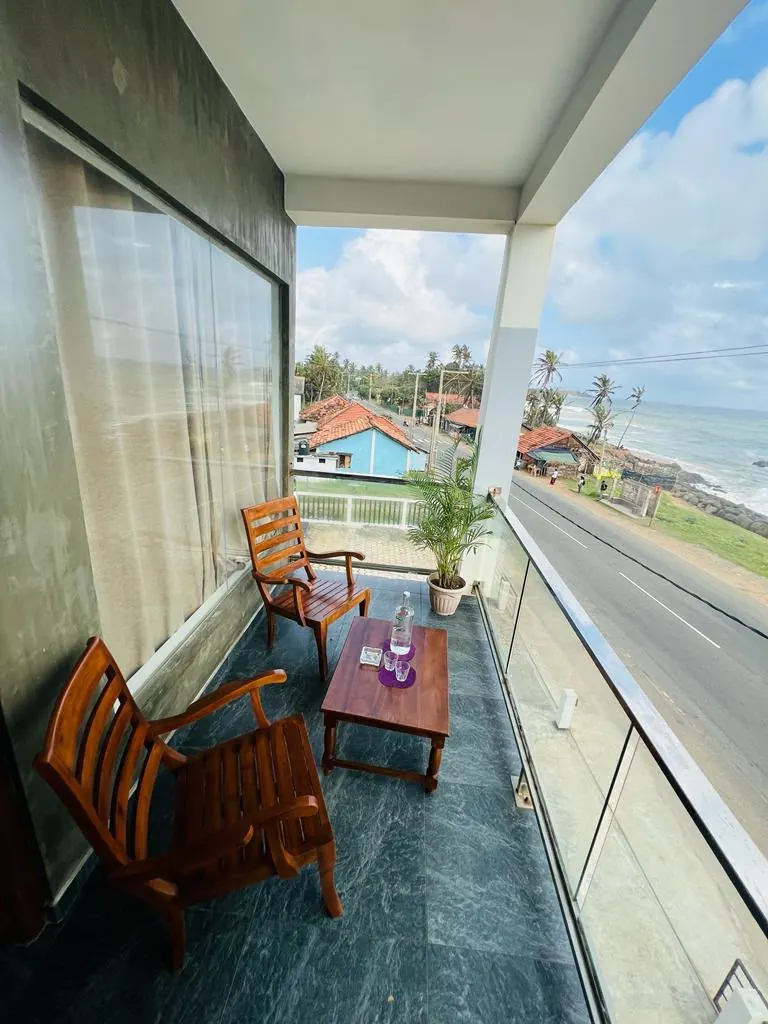 Long covered balcony with wooden seats beside a room window