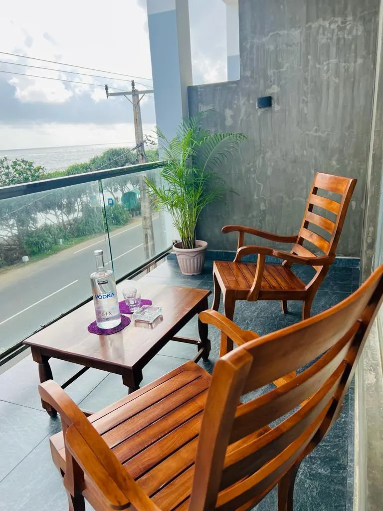 Wooden chairs and a low table on the sea view balcony