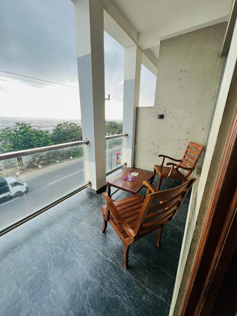 Covered side balcony with views of the coast road and ocean