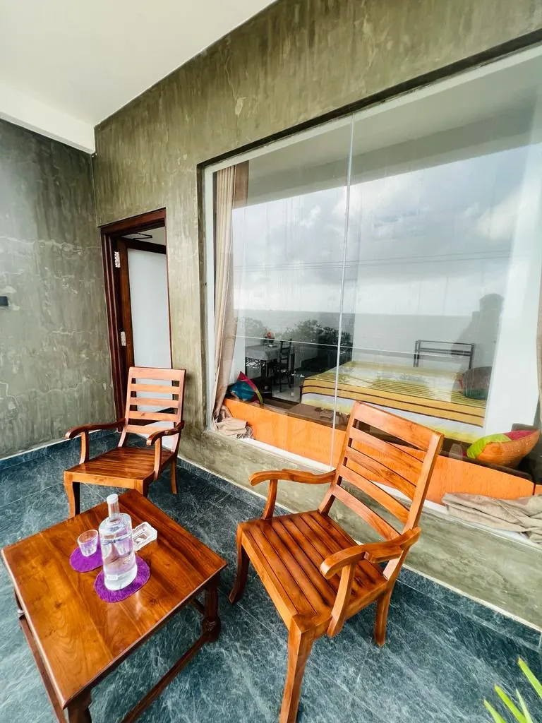 Balcony seating outside a guest room with a large window
