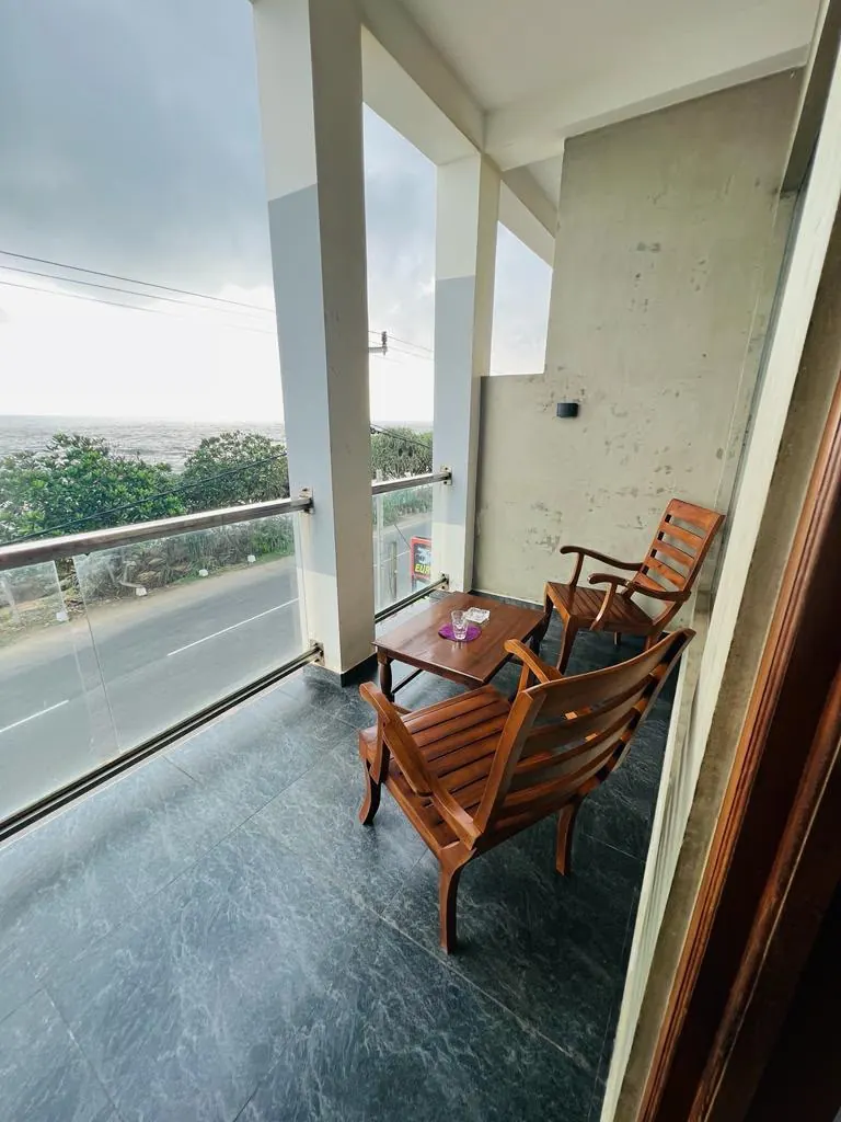 Covered sea view balcony with two wooden chairs