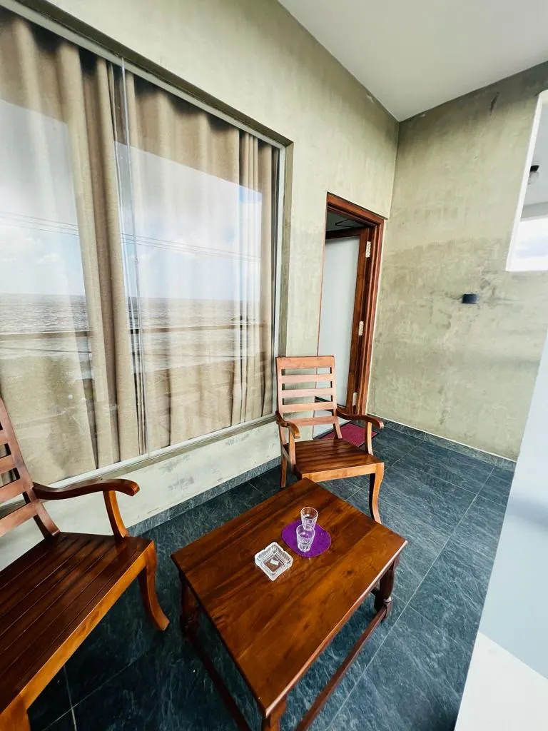 Wooden balcony seating outside a wide curtained window