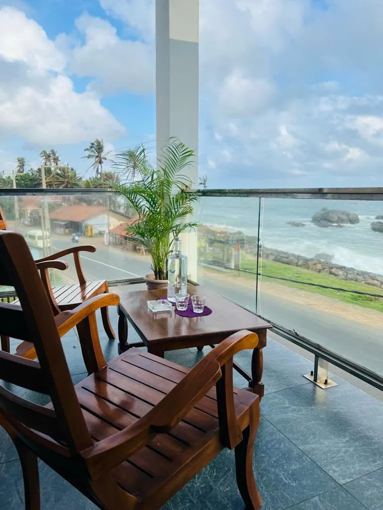 Balcony with wooden seating and a bright ocean view