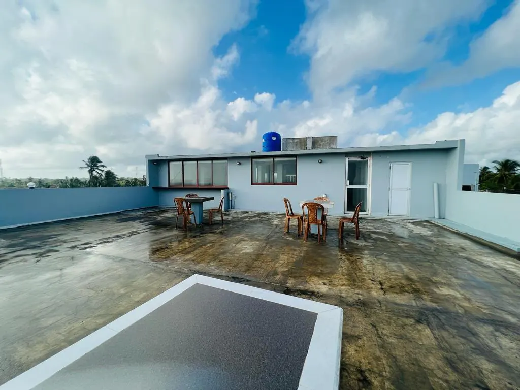 Rooftop terrace seating beside the upper building