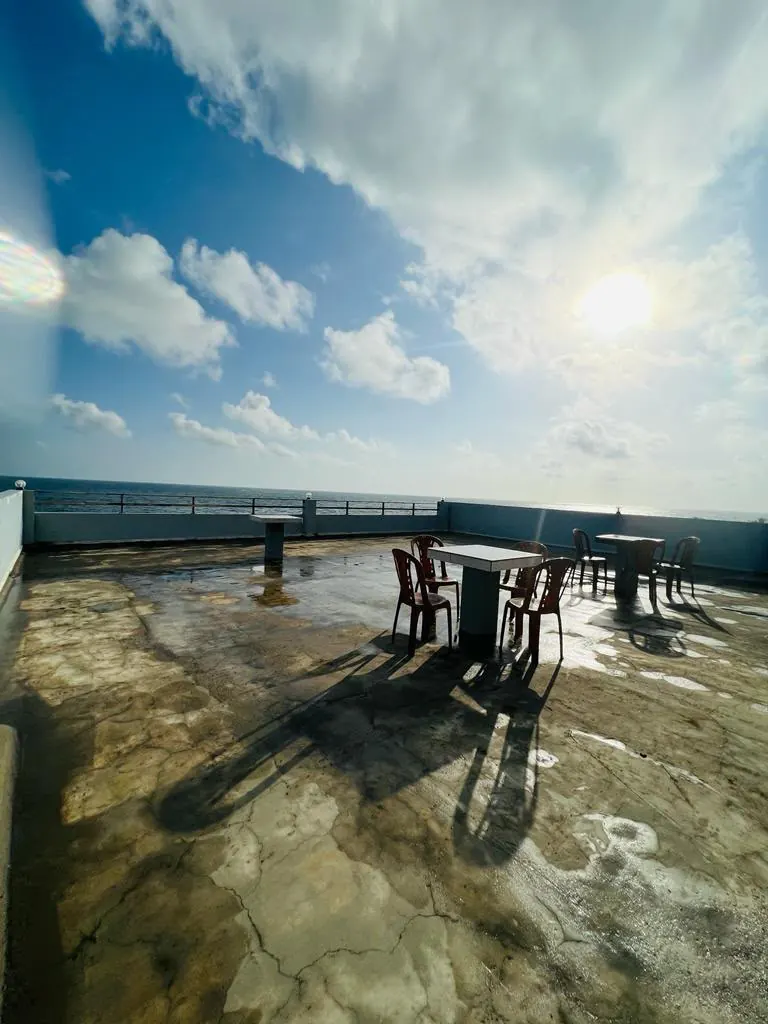 Rooftop seating in warm evening light overlooking the sea