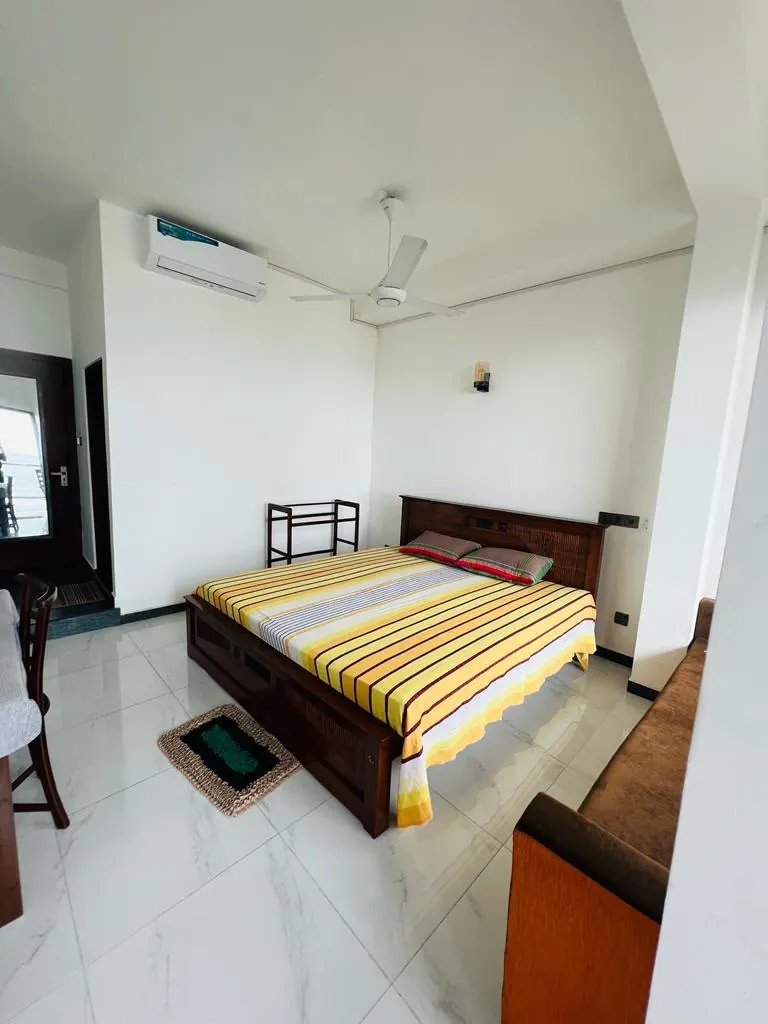 Air conditioned double room with a ceiling fan and wooden bed