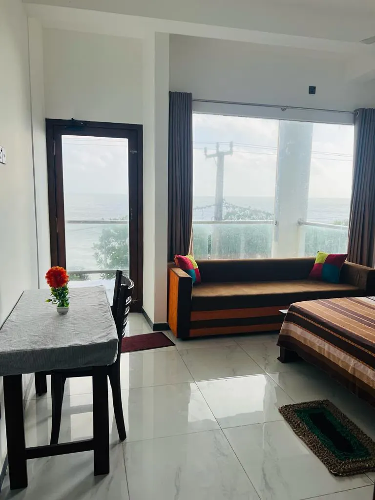 Sea view double room with a sofa, table and large windows