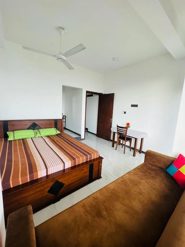 Spacious double room with a sofa and small dining table