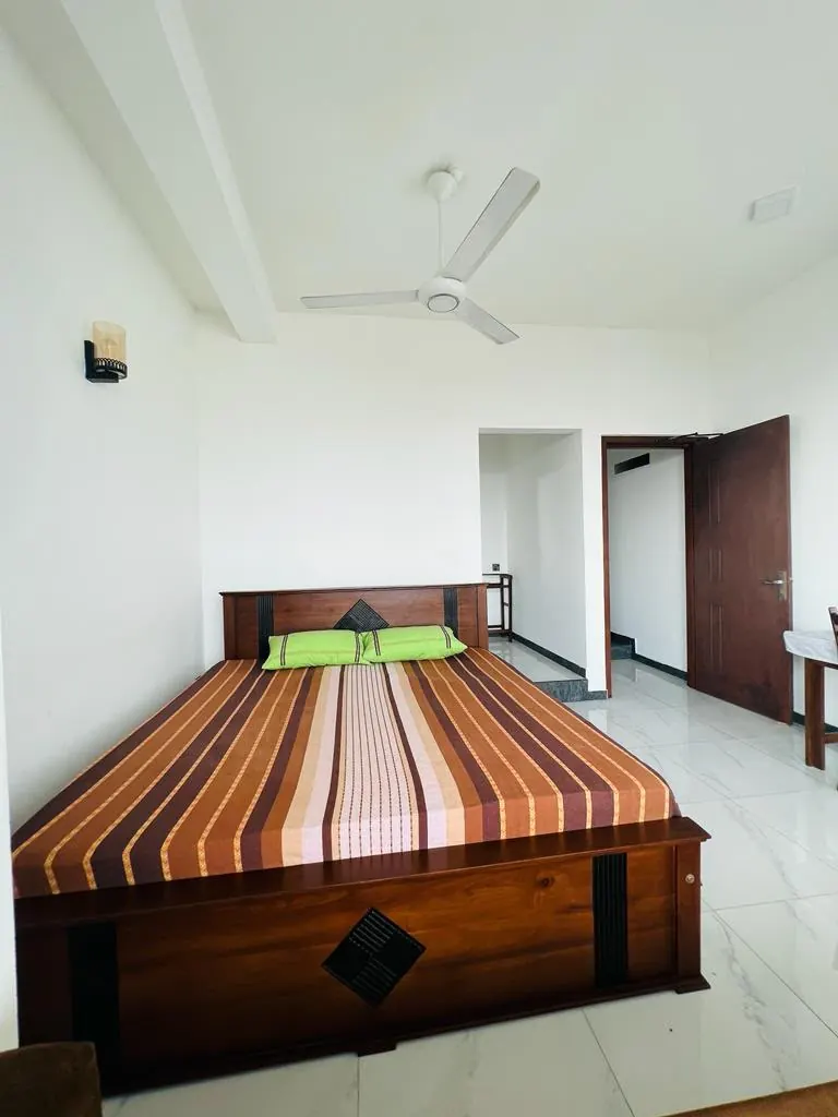 Wooden double bed in a bright tiled guest room