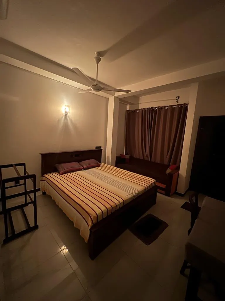 Double room with warm night lighting and a ceiling fan