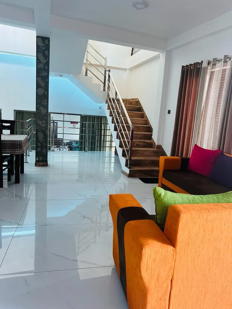 Guest lounge with colourful sofas and staircase access